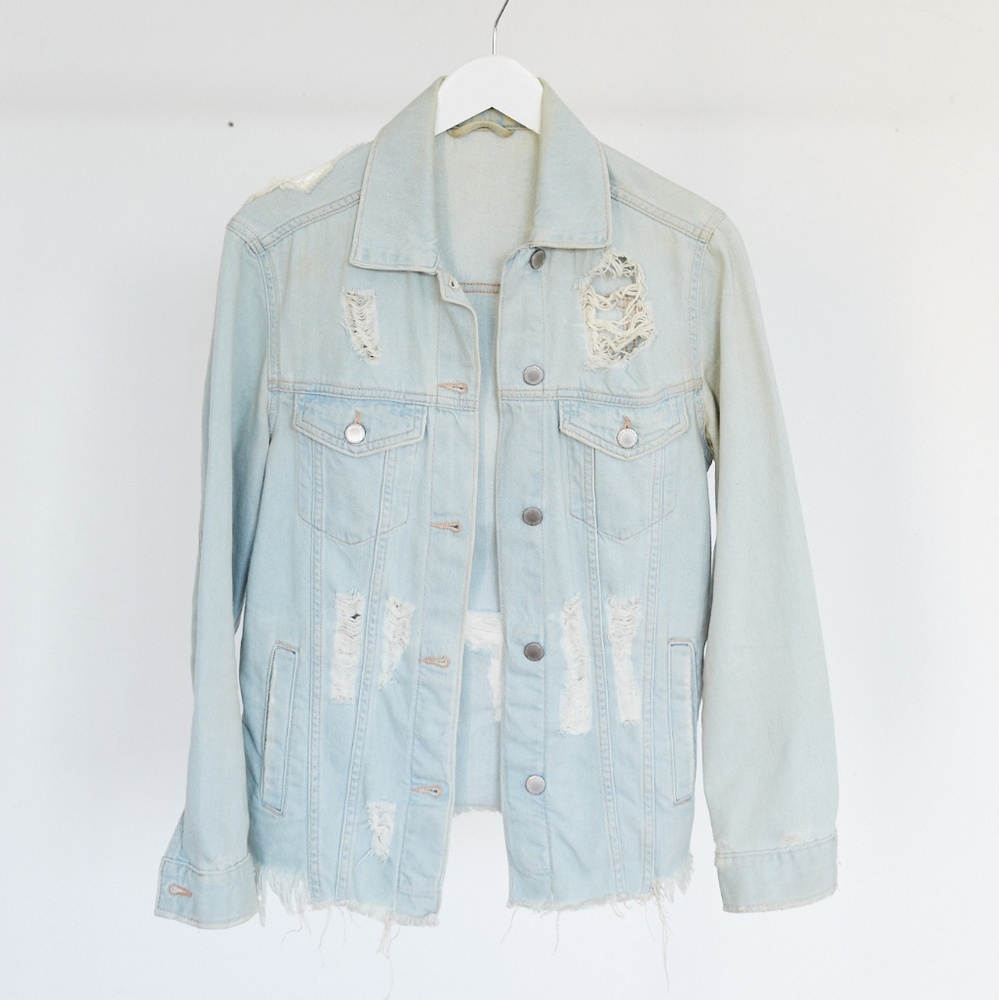 Distressed denim jacket with hand stitched patch